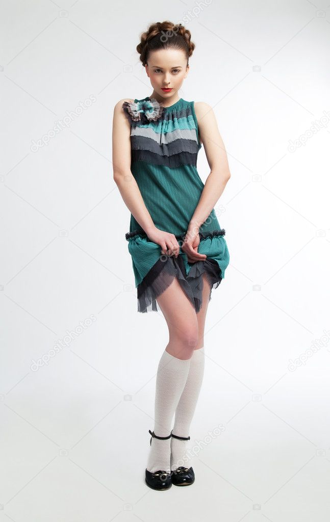 Cute young woman posing in modern green dress