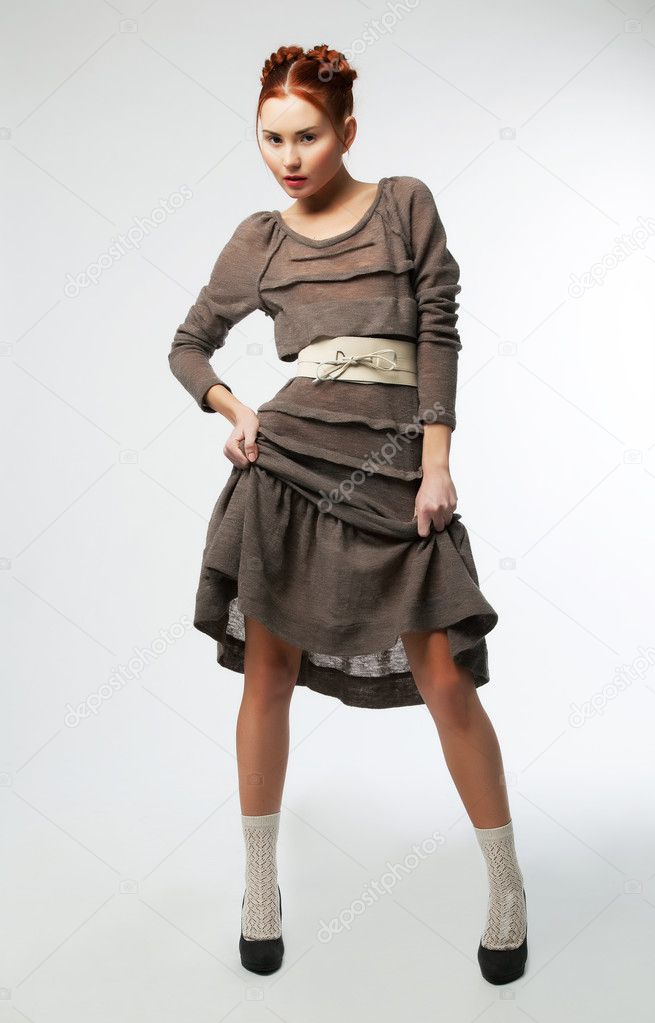 Fashionable girl in modern dress posing. Studio shot