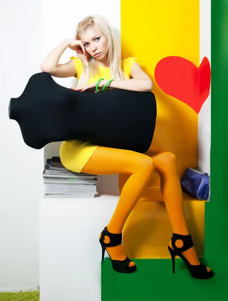 Piękna młoda kobieta blond włosy siedzi witn manekina — Zdjęcie stockowe