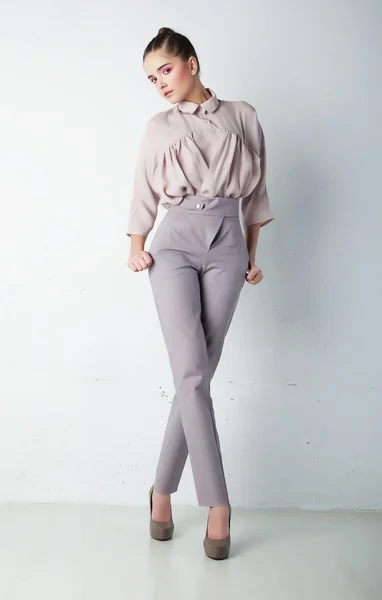 Fashionabla unga kvinna i byxor och skjorta poserar — Stockfoto