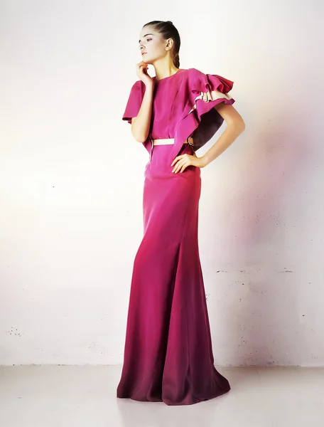 Pretty girl in fashion crimson dress studio shot — Stock Photo, Image