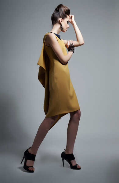 Fashionable emotional woman in modern yellow dress