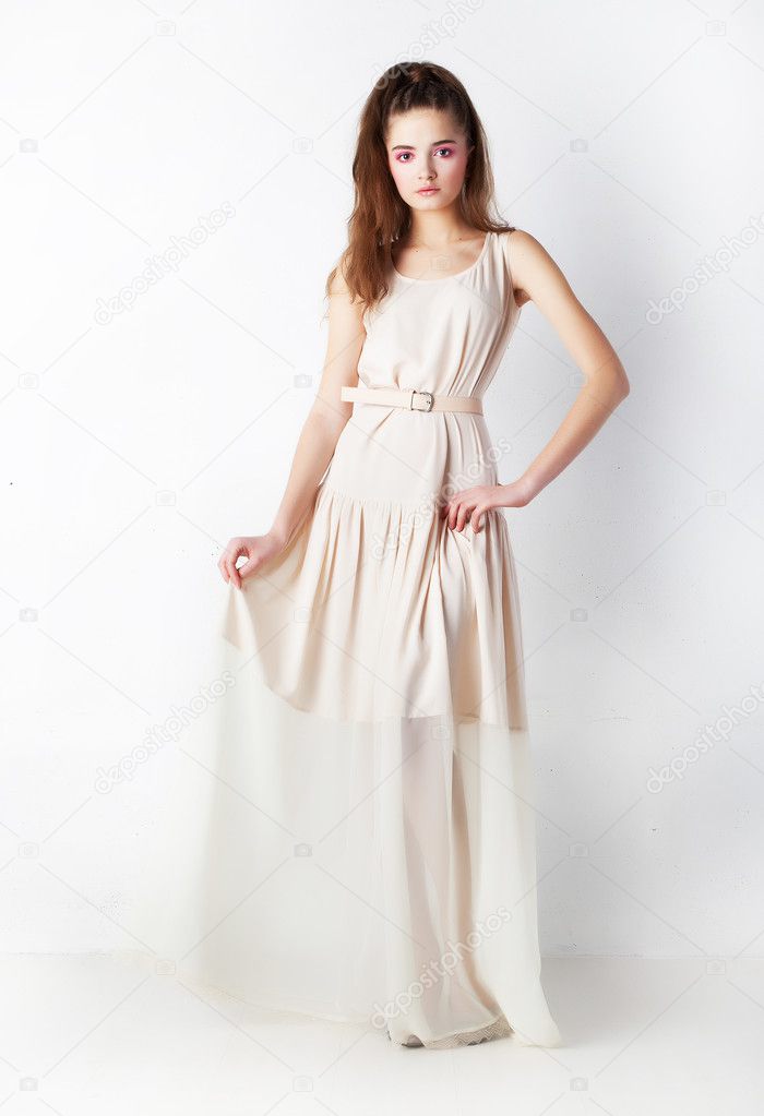 Sensual bright brunette in beige dress