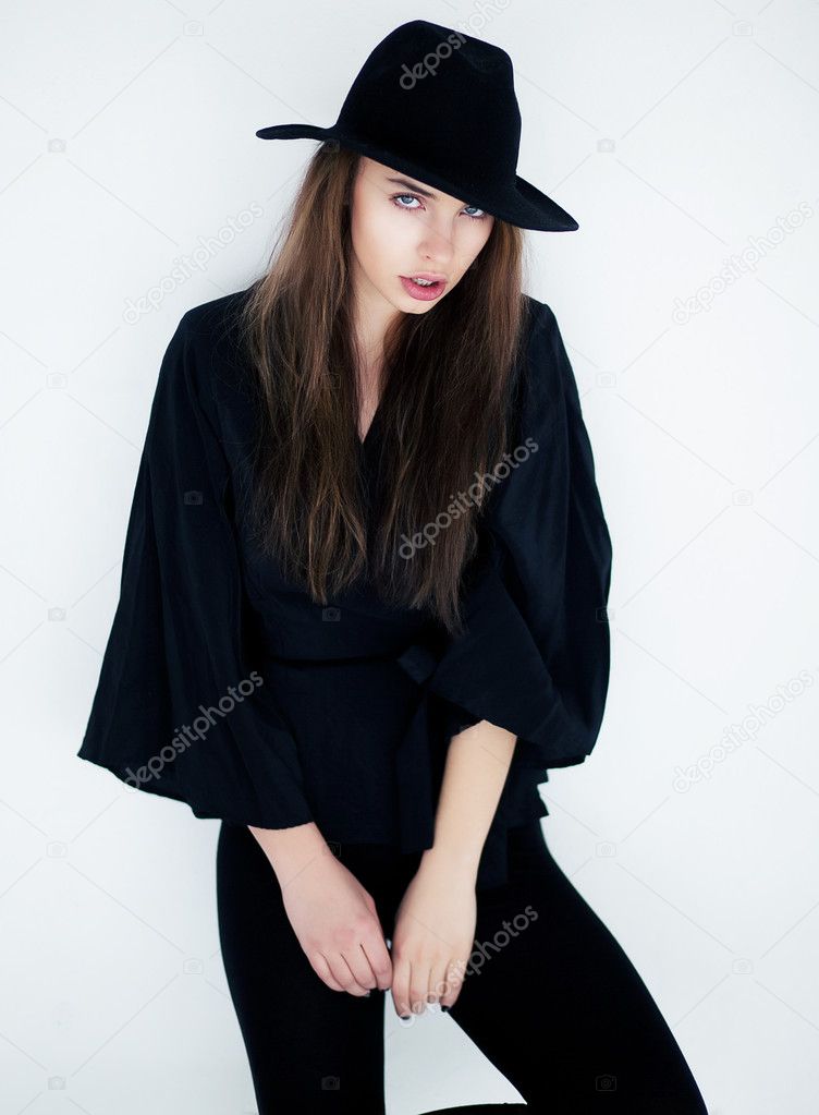 Stylish young female in fashion clothes posing