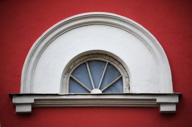 Arc attic vintage window on red stucco wall ;