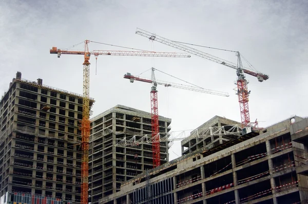 , three cranes on top of high-rise building — Stock Photo, Image