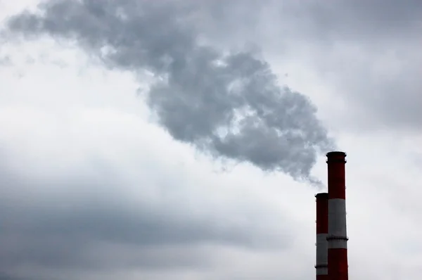 Дым исходит из дымохода промышленного завода — стоковое фото