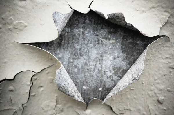 Hole in chipped paint on wall — Stock Photo, Image