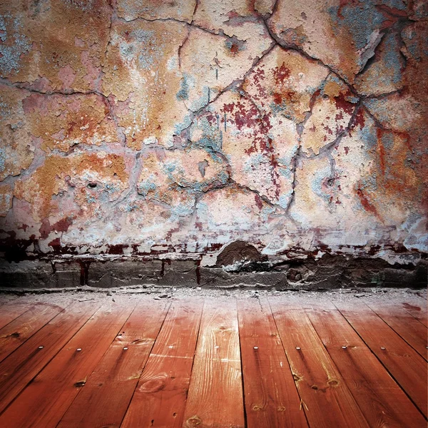 Quarto castanho escuro com parede de estuque descascada e piso de madeira — Fotografia de Stock