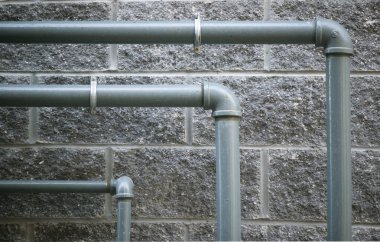 Pipes against grungy stone wall clipart