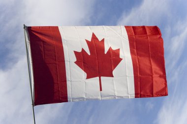 Candian flag against blue sky clipart