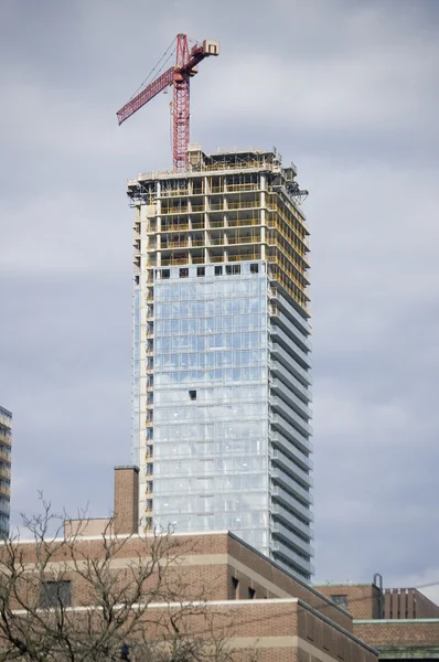Paisagem com um guindaste no topo do edifício alto — Fotografia de Stock