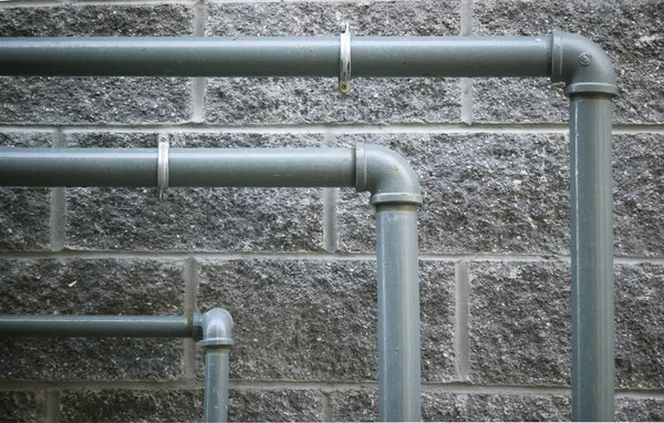 stock image Pipes against grungy stone wall