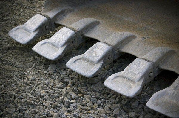 Teeths of shovel of excavator; industrial background