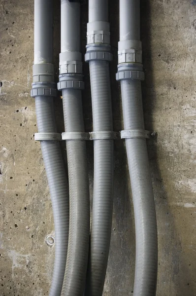 Tubi idraulici sul muro di mattoni intemperie — Foto Stock
