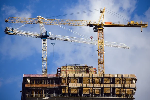 Kraan op de top van moderne gebouw in aanbouw — Stockfoto