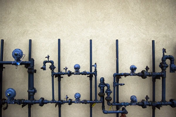 Трубы водопроводные на грубой стене — стоковое фото