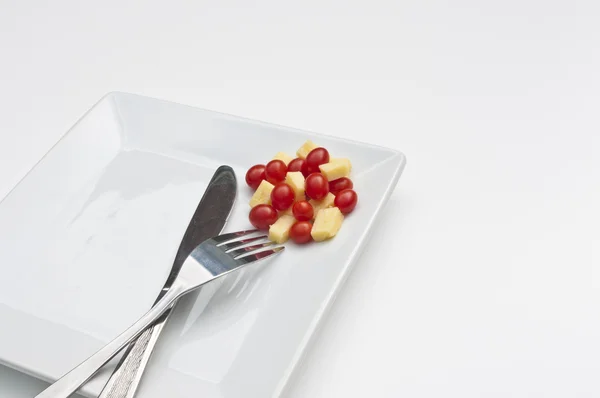 Chese e tomates em uma chapa com uma faca e garfo — Fotografia de Stock