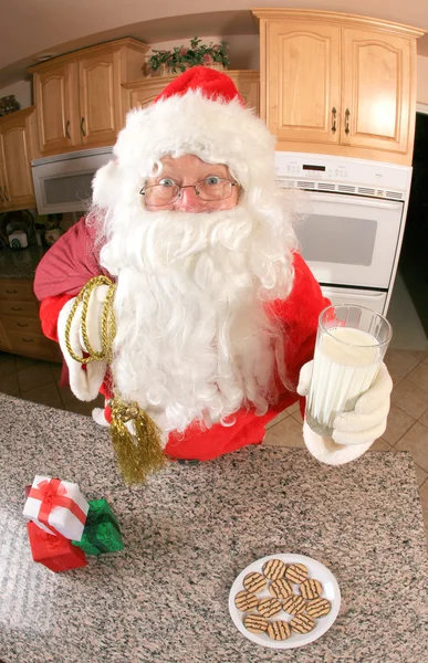 Santa na cozinha comer biscoitos — Fotografia de Stock
