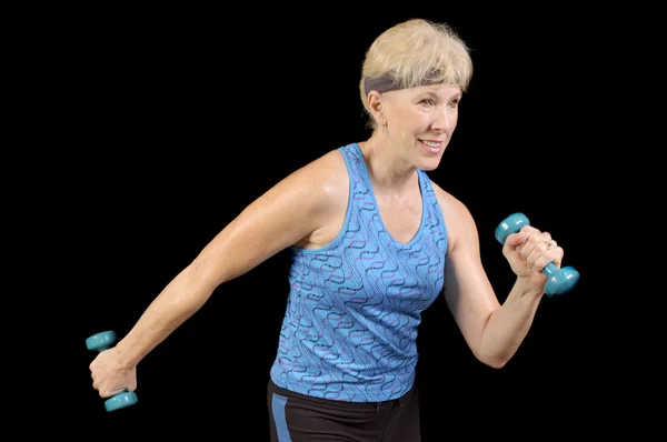 Attractive baby-boomer exercising with weights isolated over black — Stock Photo, Image