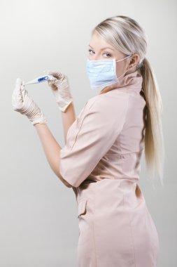 Young nurse in medical gloves and hospital mask on a white background. clipart