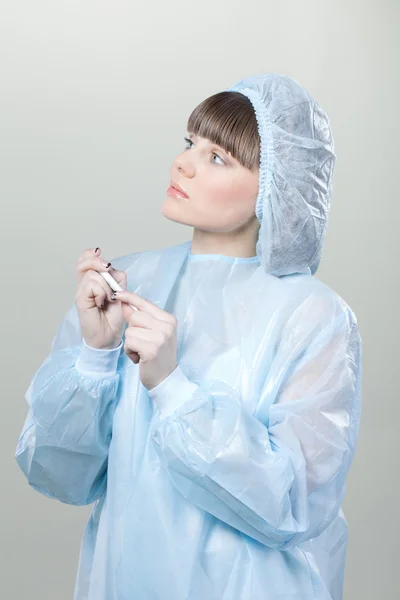 Junge Krankenschwester mit Maske und Thermometer in der Hand — Stockfoto