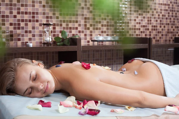 Donna felice di ricevere un massaggio con pietra calda in un centro benessere — Foto Stock