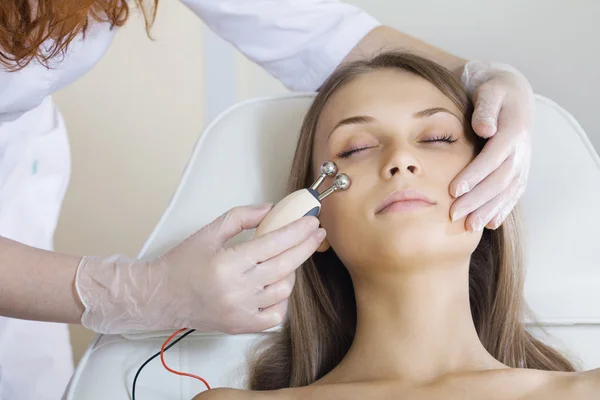 Vrouw met een stimulerende gezichtsbehandeling van een therapeut — Stockfoto