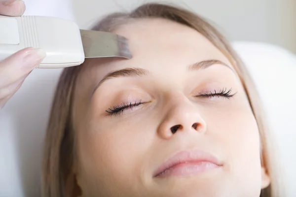Woman lies on a table in a beauty spa getting a treatment — Stock Photo, Image