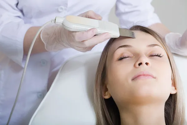 Woman lies on a table in a beauty spa getting a treatment — Stock Photo, Image