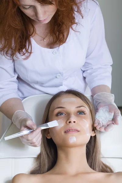 Mulher bonita recebendo massagem facial com olhos fechados — Fotografia de Stock