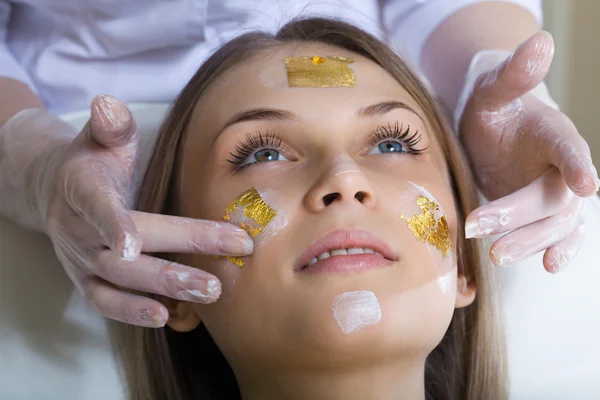 Piękna młoda kobieta odbiera masaż twarzy z zamkniętymi oczami — Zdjęcie stockowe