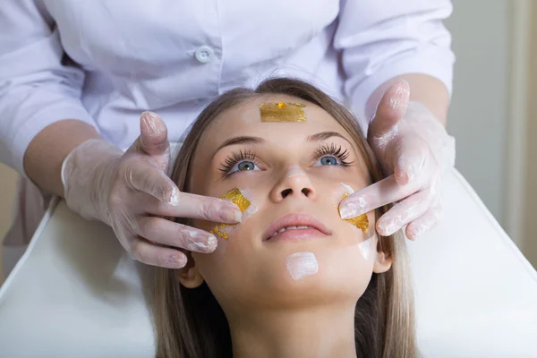 Mooie jonge vrouw gezicht massage met gesloten ogen ontvangen — Stockfoto