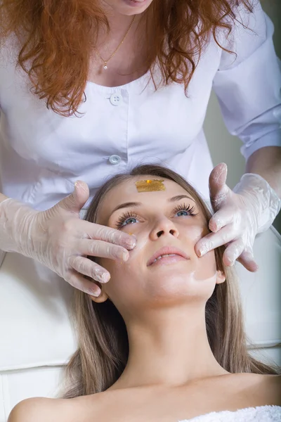 Belle jeune femme recevant un massage facial avec les yeux fermés — Photo