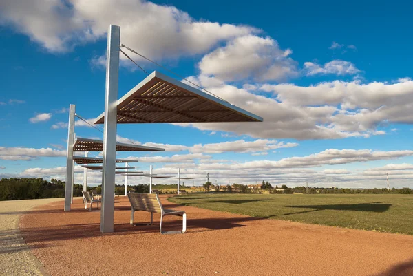 stock image Row of park bench with parasol