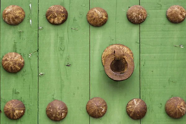 Oxide metal handle on old green wood door