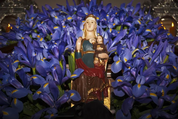 Maryja siedzi z dzieckiem Jezusa pośród kwiatów — Zdjęcie stockowe