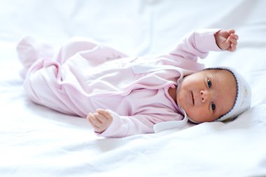 Baby girl on the bed clipart
