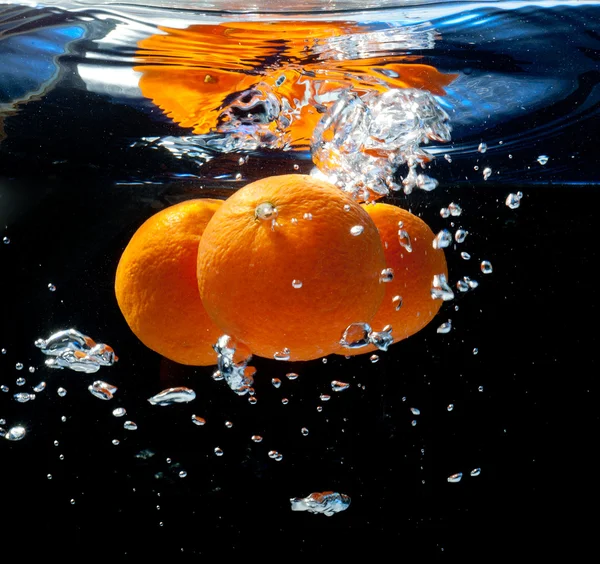 Три апельсини у воді — стокове фото