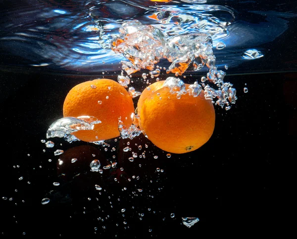 在水中的三个桔子 — 图库照片