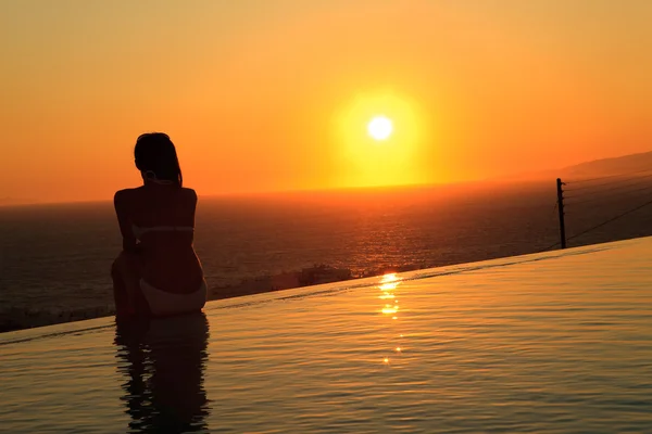 Красива леді, що сидить біля розкішного готелю з видом на басейн Стокове Фото