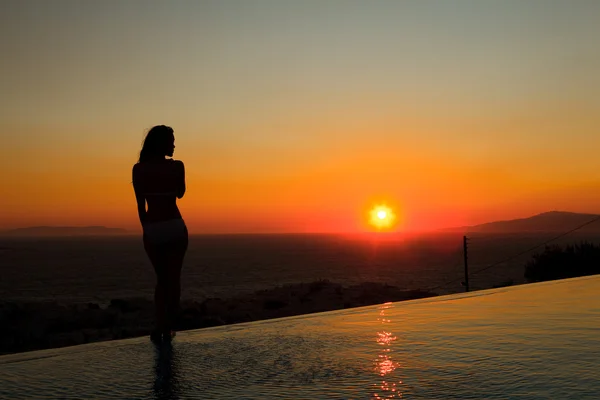 Красива леді, що стоїть на розкішному готелі з видом на басейн Ліцензійні Стокові Зображення