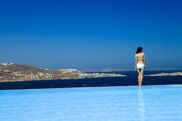 Μια όμορφη κοπέλα για την πισίνα που βρίσκεται σε Μύκονος, Ελλάδα Royalty Free Φωτογραφίες Αρχείου