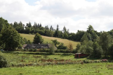 Farmhouse behind the hill clipart