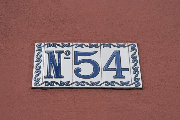 Número da casa na parede vermelha — Fotografia de Stock