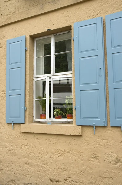 Окно с голубыми ставнями — стоковое фото