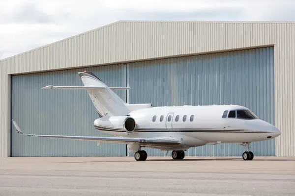 Jet privado estacionado frente al hangar — Foto de Stock