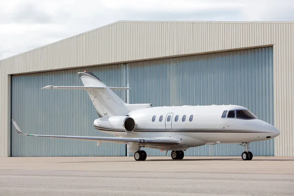 Private jet parked in front of hangar Stockafbeelding