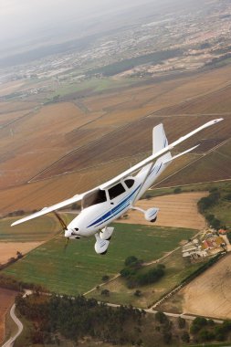 Small airplane flying over farm clipart