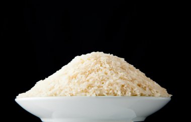 siyah arka planda çiğ pirinç kase